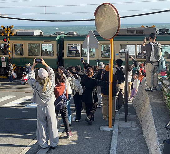 （写真2）鎌倉高校前駅の踏切はアニメの影響で観光客が集中するようになった